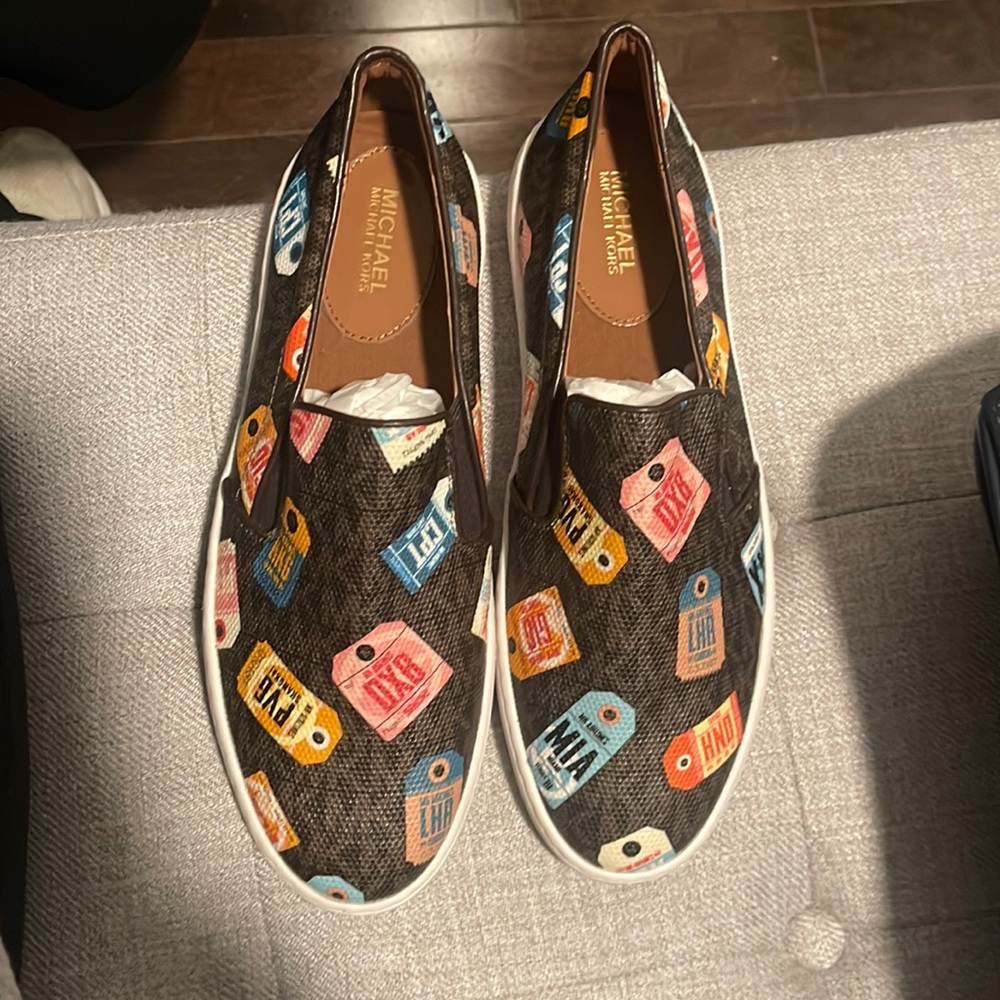 Brand new Michael Kors Keaton slip on with airport tags logo